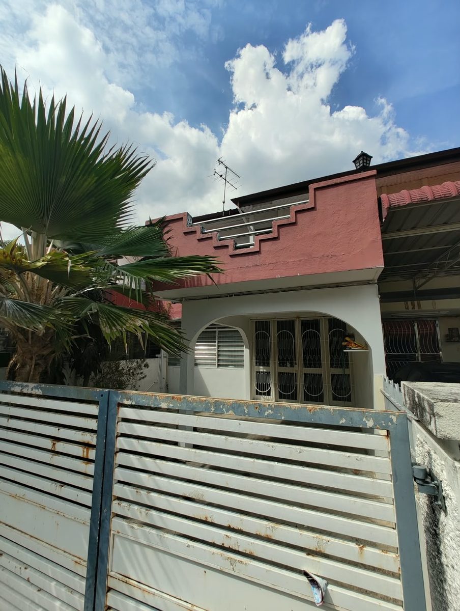 Original pink-rendered facade and old metal gate of a 30-year-old Penang terrace house before facade reconstruction