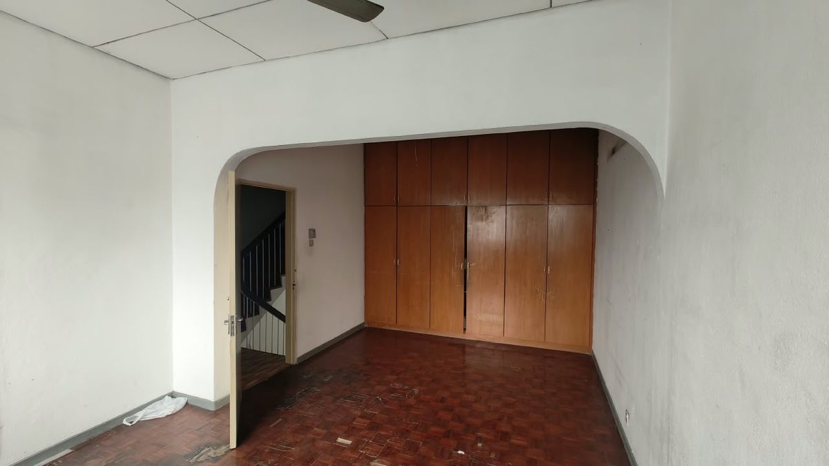 Original split-level staircase and arched opening dividing the ground floor of a 30-year-old Penang terrace house