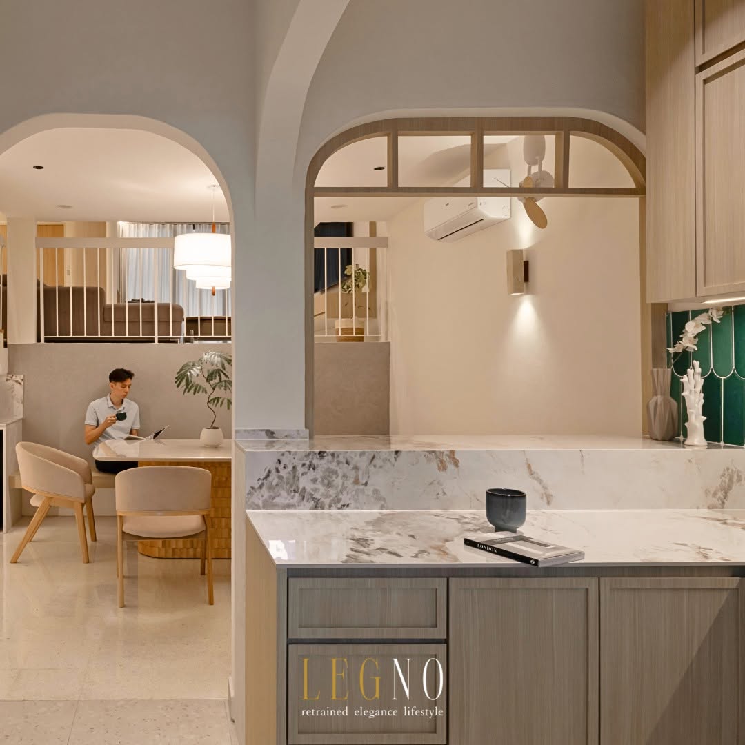 Dry kitchen with marble counter and arched opening framing the dining area in a Penang terrace house