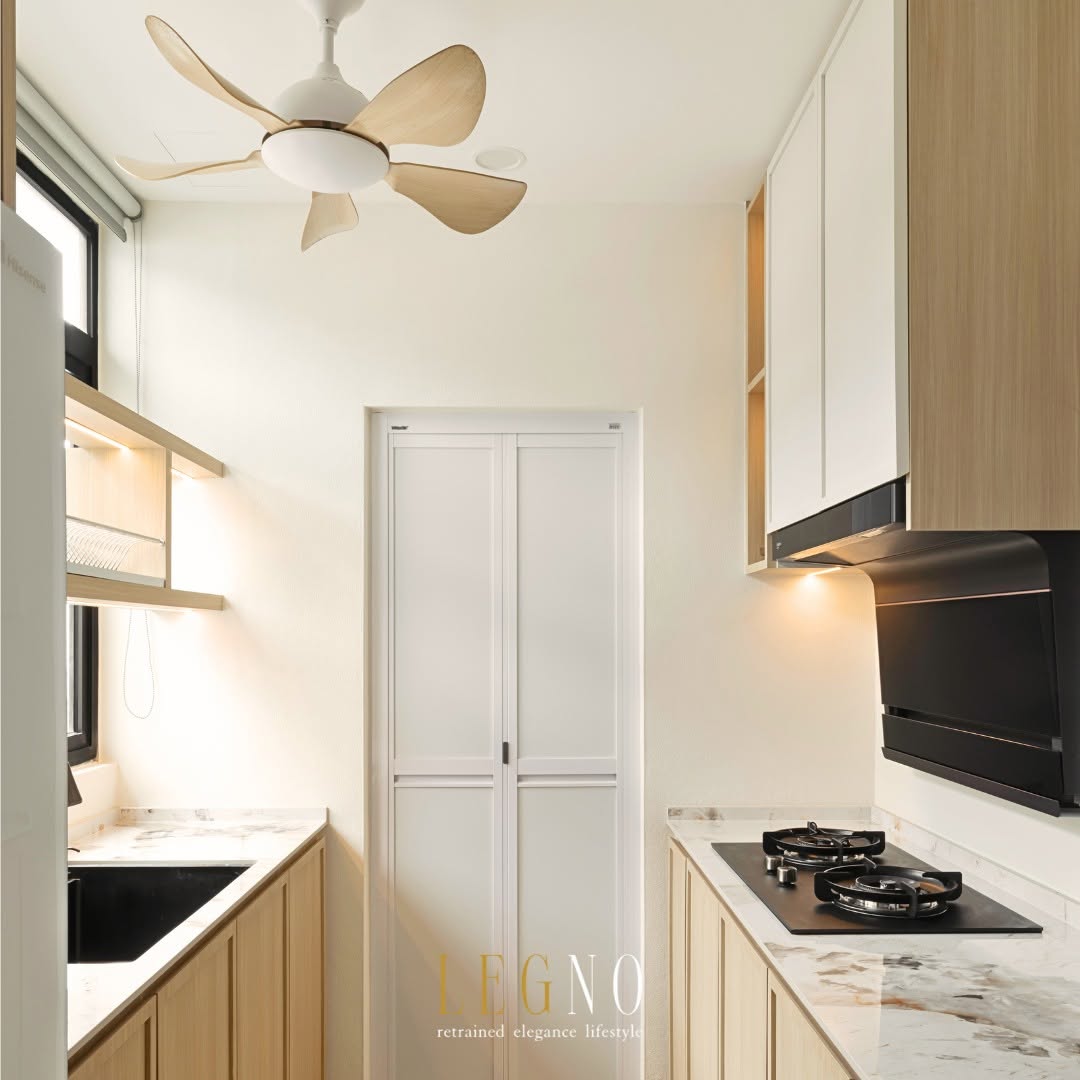 Wet kitchen with gas hob, cooker hood and marble backsplash behind a white bifold door in Penang